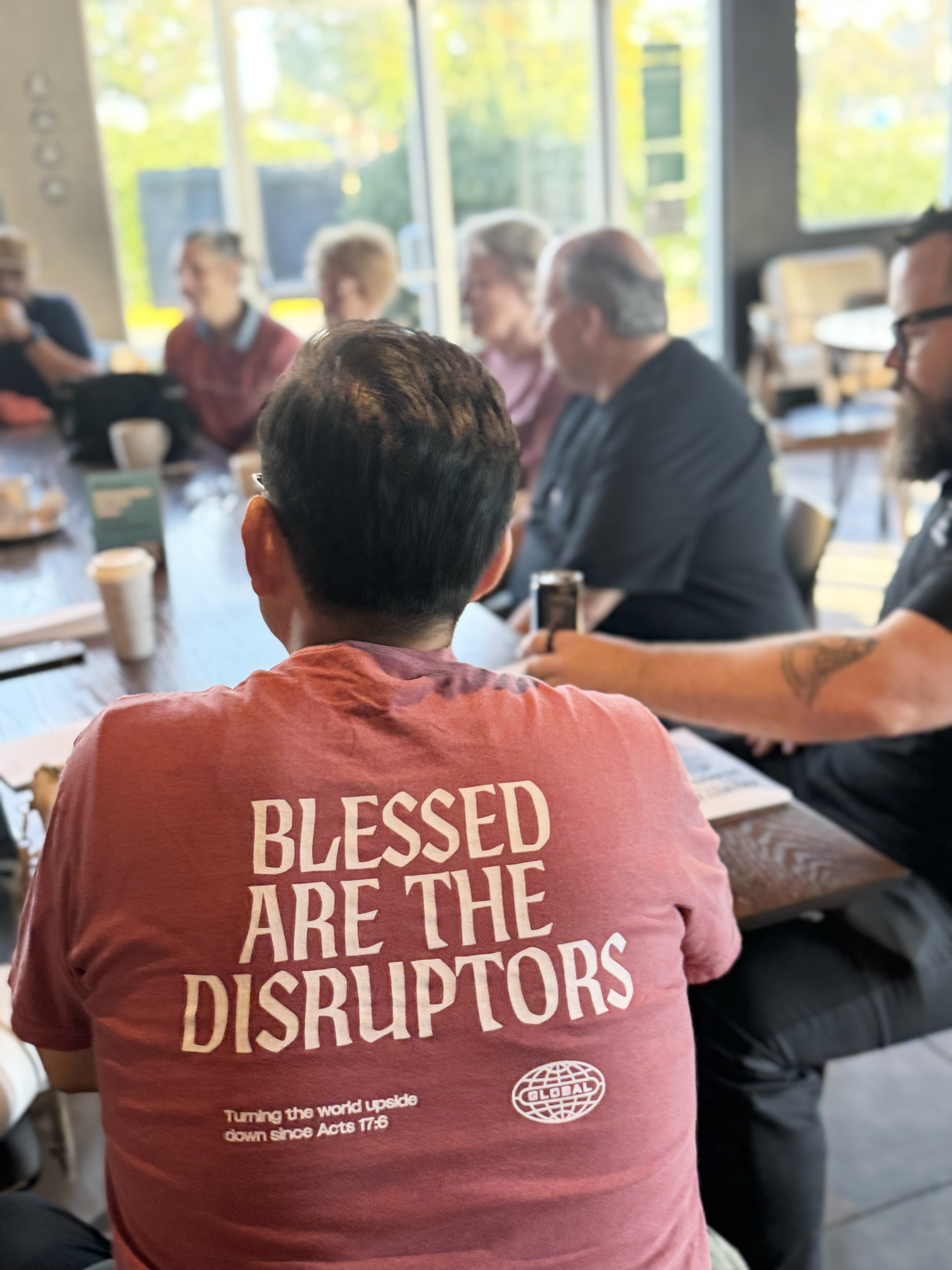 Close-up of the full 'Blessed Are The Disruptors' t-shirt design, worn at a meetup
